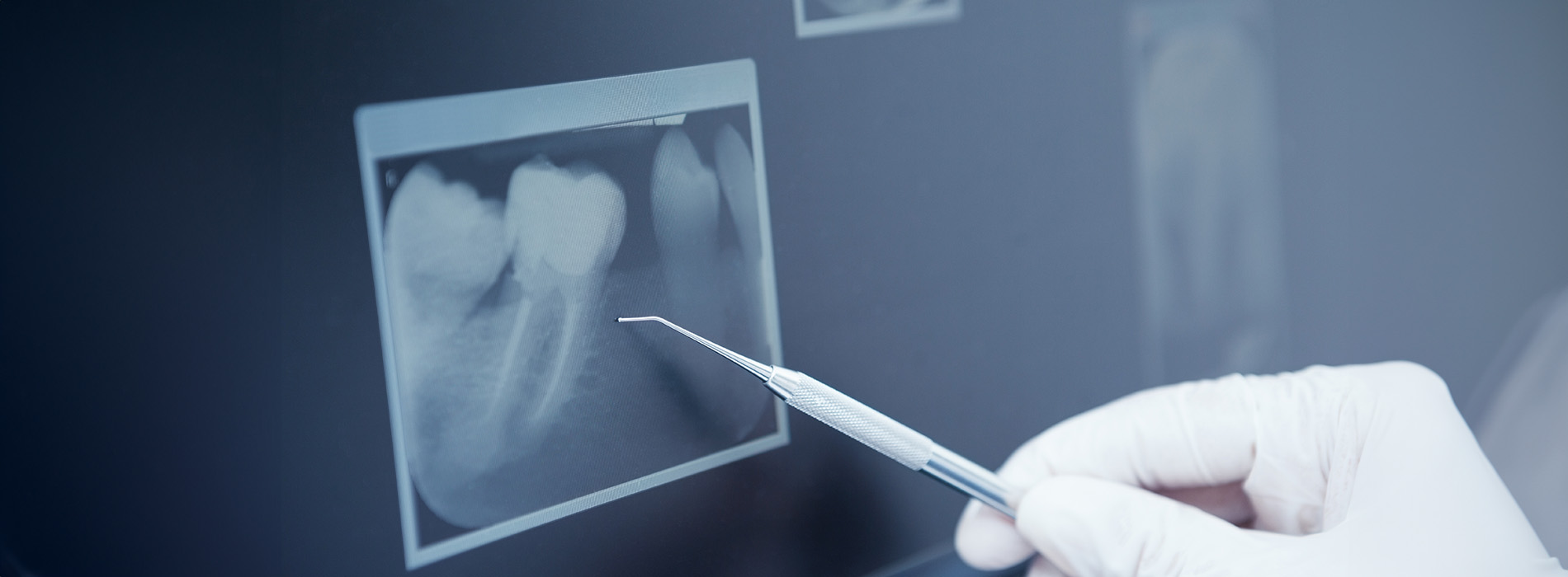 The image shows a group of people, possibly professionals given their attire and the setting that appears to be an office or professional environment. They are gathered around a table with a laptop on it, engaged in what seems to be a discussion or meeting.