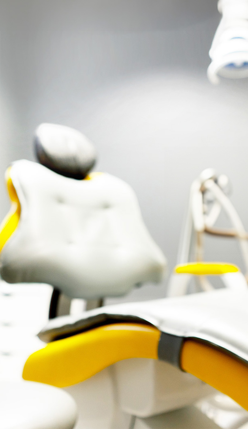 The image shows a modern dental or medical office interior with a dental chair, equipment, and a clean, professional environment.